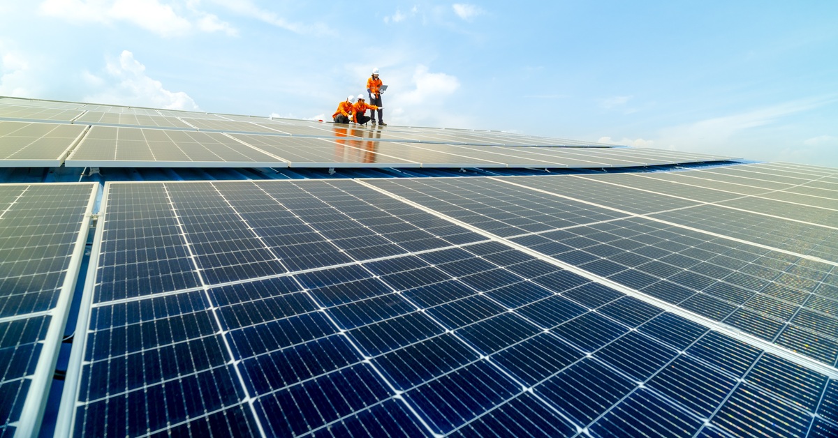 engineer man inspects construction of solar cell panel or photovoltaic cell by electronic device. Industrial Renewable energy of green power. factory worker working on tower roof.
